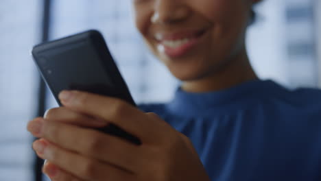 closeup smartphone in woman hands. happy business woman using mobile phone