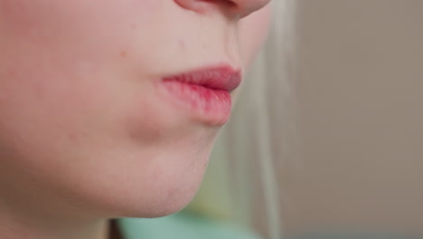 close up of white kid interacting while eating popcorn, natural skin texture visible, indoor casual moment, focused expression, light background, youthful leisure time