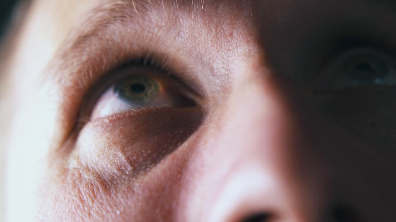 gran ojo de persona de color verde mira hacia arriba vista de cerca