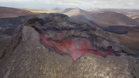 Increíble-Vista-Aérea-De-Drones-Del-Cráter-Del-Volcán-Activo-Volcán-Fagradalsfjall-Con-Rocas-De-Lava-Cayendo-En-Islandia