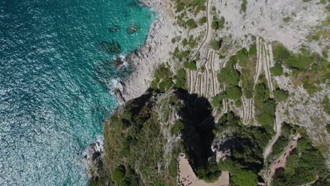 Aerial-Bird's-Eye-View-Above-Cliffs-of-Capri-Coastline-on-Sunny-Italy-Day