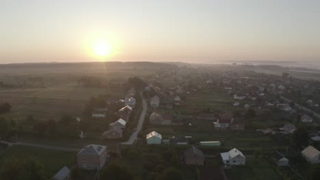 aerial view of a village at sunrise with fog