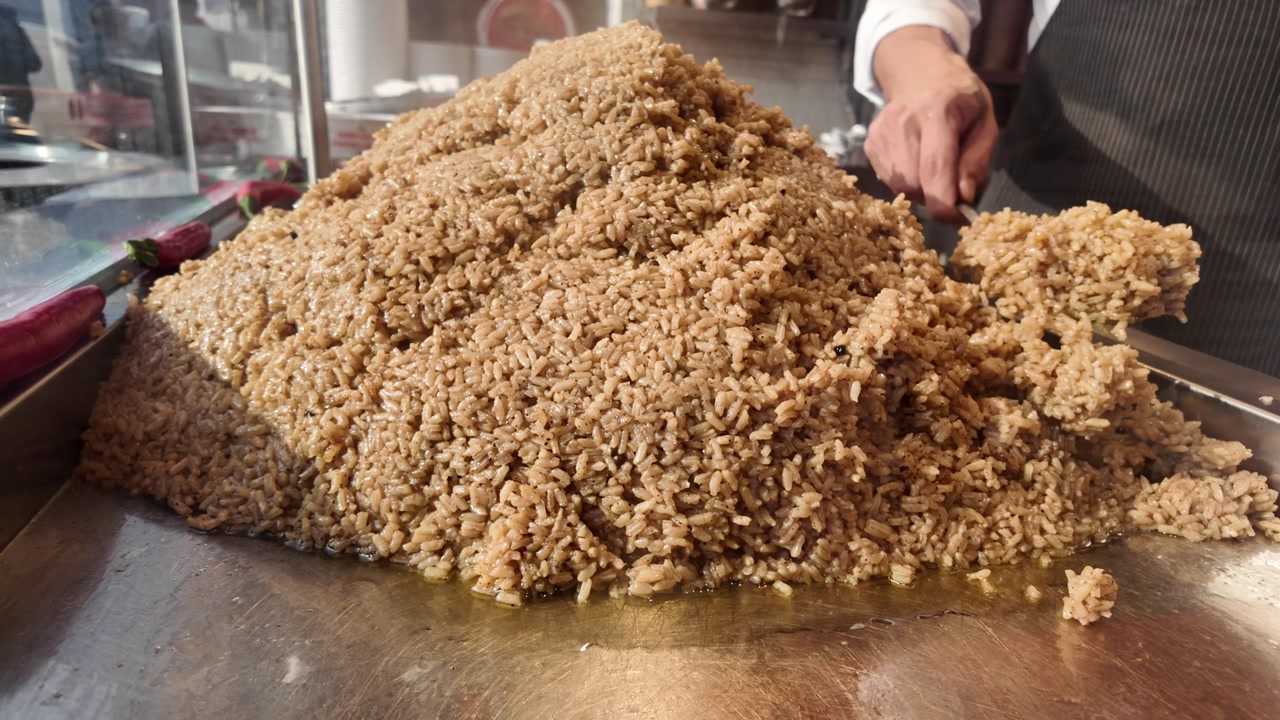 Chef Serving a Large Pile of Cooked Rice Pilaf