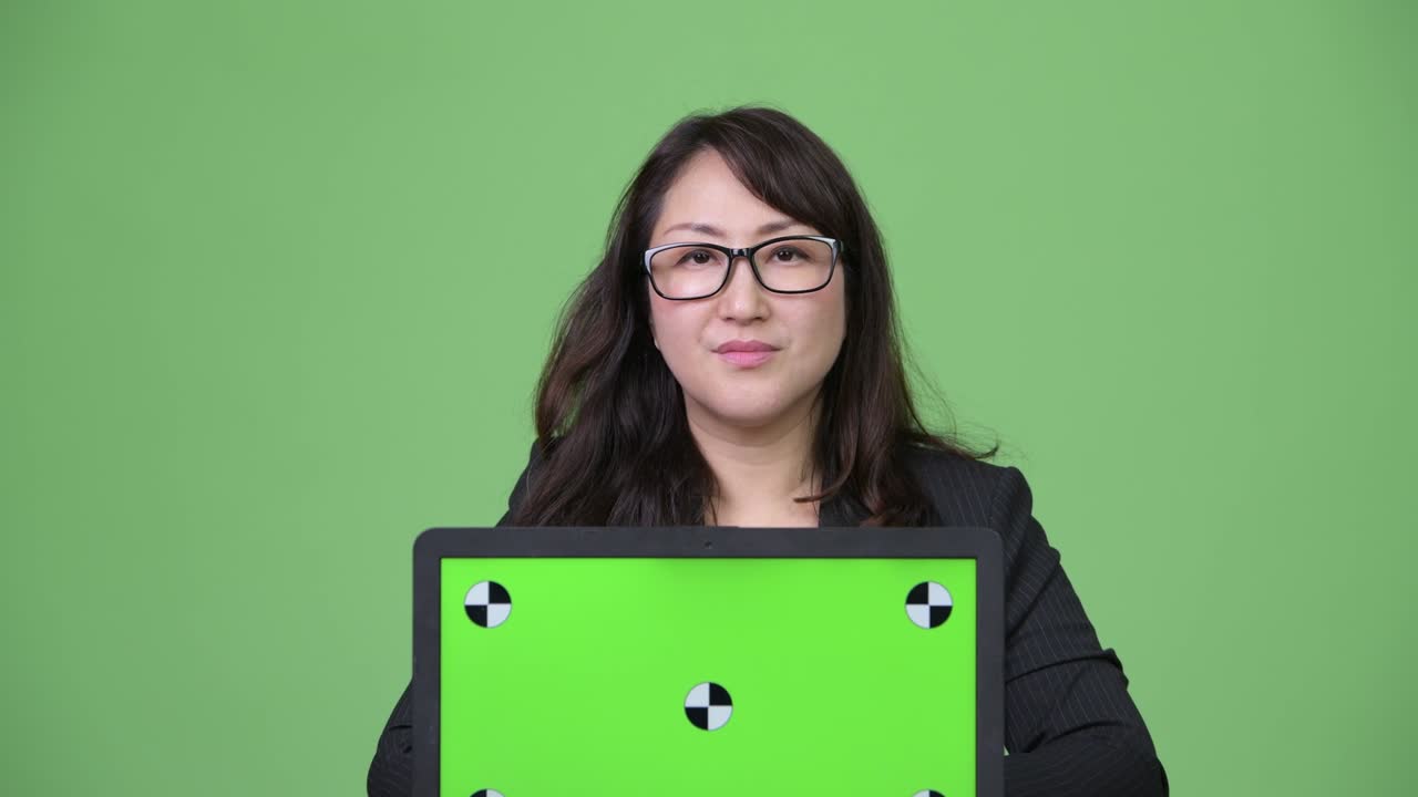 성숙하고 아름다운 아시아 사업가 여성이 노트북을 보여주고 있습니다.