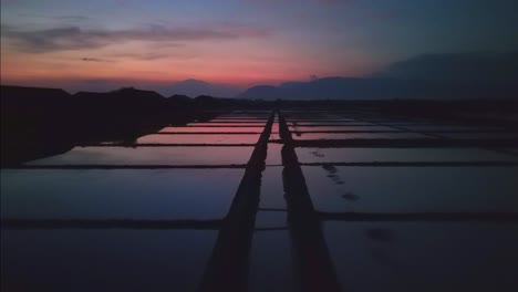 campos de sal, reflejos planos de un atardecer rojo oscuro