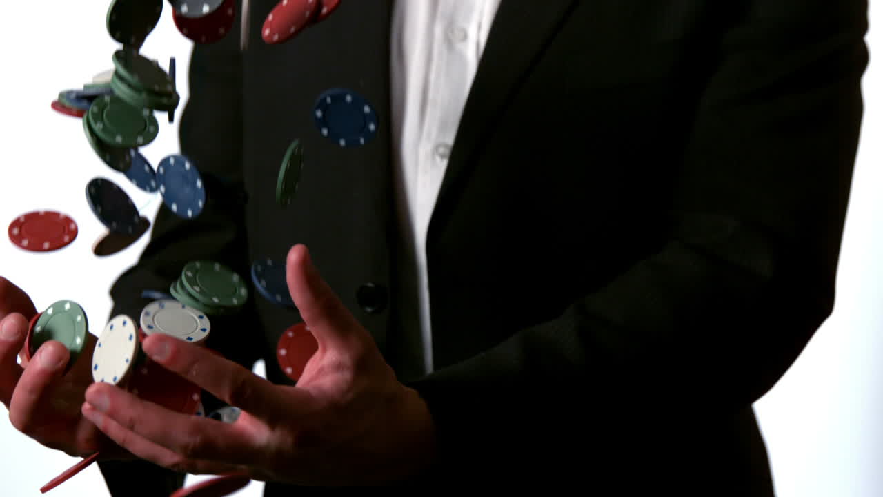 슈트 를 입은 남자 가 떨어지는 카지노  을 잡고 있다