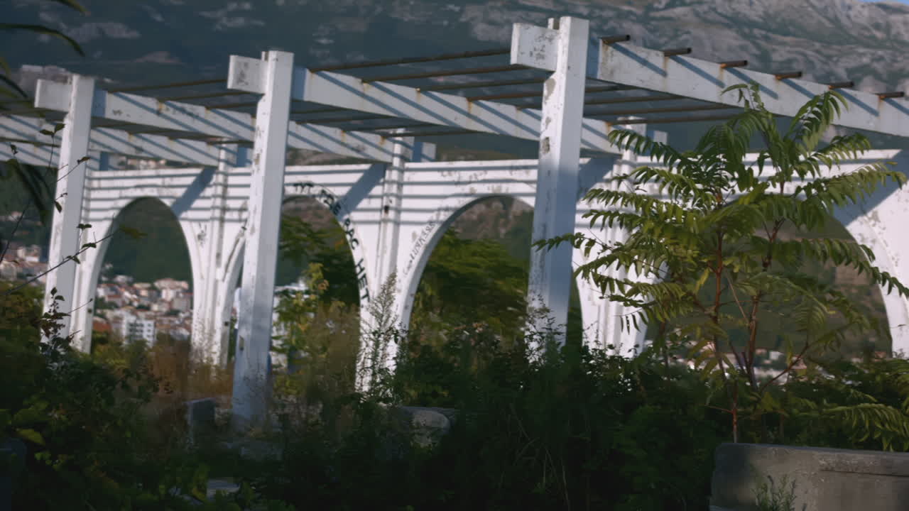 gazebo abandonado con plantas cubiertas y vista a la montaña