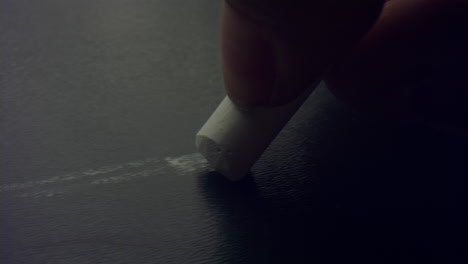 Closeup-woman's-fingers-holding-chalk-piece