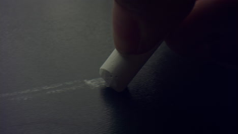 Closeup woman&#039;s fingers holding chalk piece