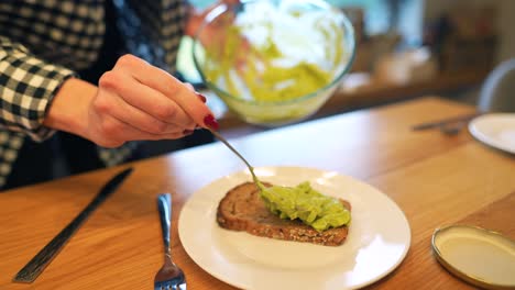 una mujer preparando tostadas de aguacate.