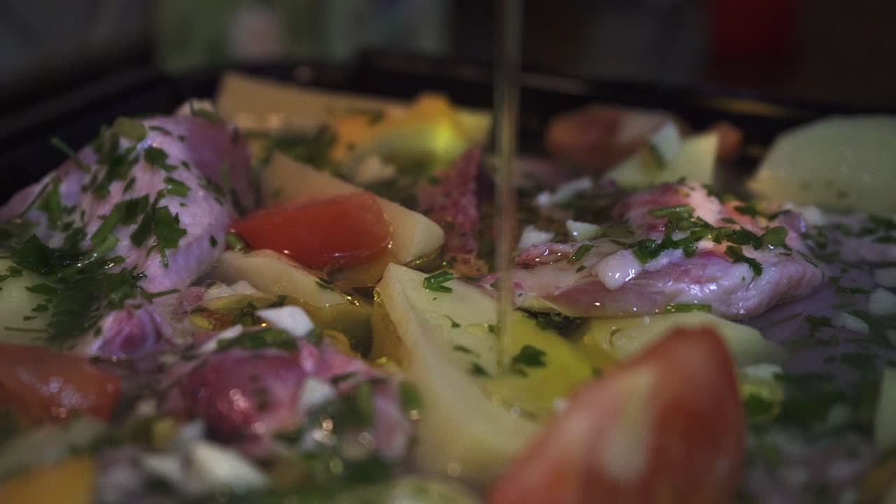 una mujer puso aceite de oliva sobre un pollo asado con patatas en un horno tradicional en una cocina clásica a cámara lenta