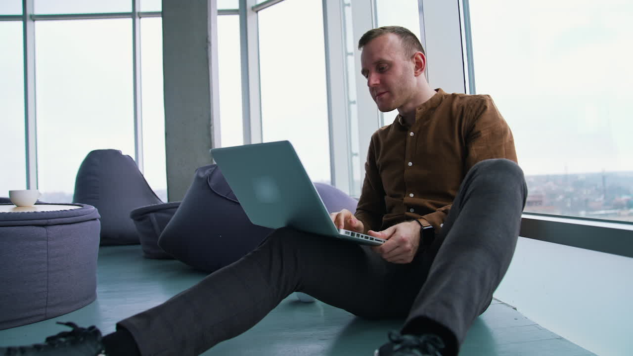 young man sitting on a floor with laptop computer. Work stress concept of man