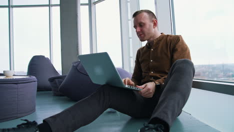 young man sitting on a floor with laptop computer. work stress concept of man