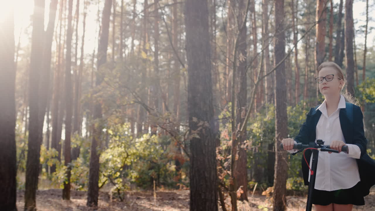 여학생은 키 큰 나무가 있는 공원에서 스쿠터를 탄다 1