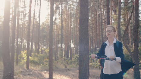 Schulmädchen-Fährt-Roller-In-Einem-Park-Mit-Hohen-Bäumen-1