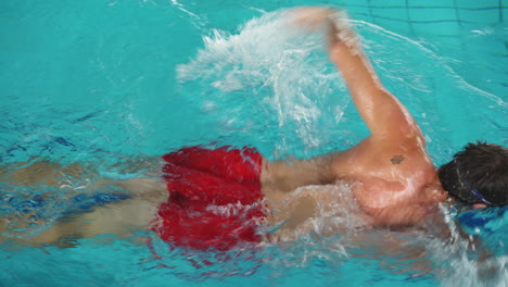 hombre caucásico nadando en la piscina usando la técnica de estilo libre-2