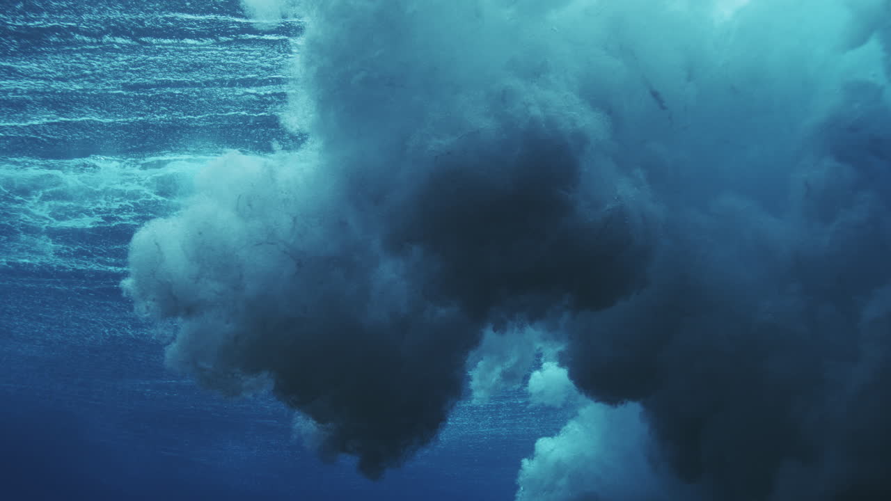 Turbulencia oscura de olas bajo el agua con burbujas densas y una atmósfera oceánica azul sombría.