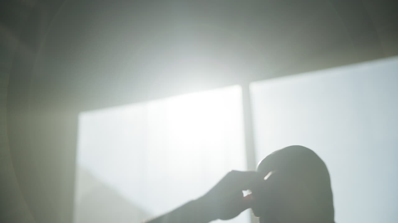 Silhouette of a man exercising in a backlit room
