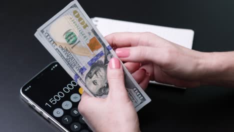dollars in the hands of a woman, the girl counts banknotes, paper money. family budget, bill payment