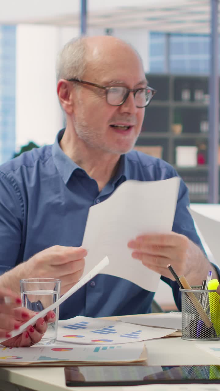 Vertikal video: Finansiel rådgiver bruger lommeregner til at udarbejde fremskrivning for at sikre opsparing.
