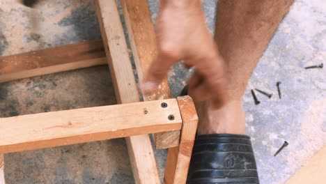 Carpintero-Hábil-Que-Emplea-Un-Taladro-Eléctrico-Para-Colocar-Tornillos-En-Una-Pequeña-Silla-De-Madera-En-Su-Pequeño-Taller-Para-Vender-Y-Apoyar-La-Economía-Local