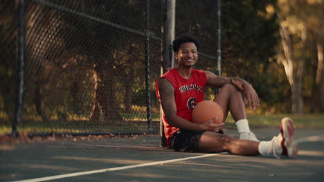 man sitting on basketball court