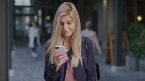 portrait young beautiful blonde woman using smartphone in city enjoying relaxed urban lifestyle browsing online messages texting on mobile phone slow motion