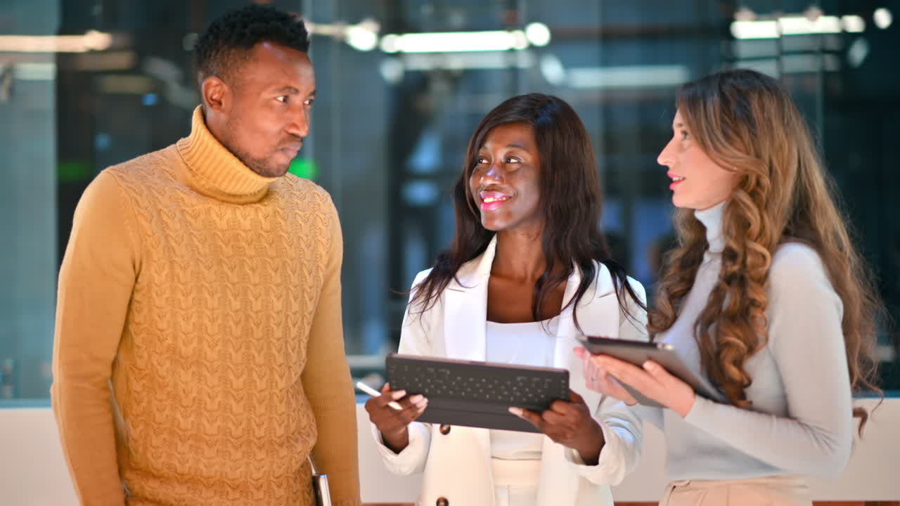 Multiracial group of people in an office discussing business using tablets
