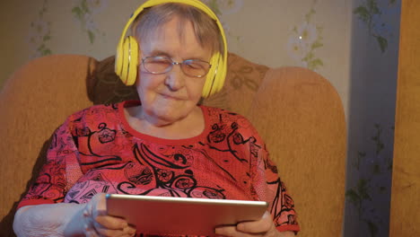 Modern-Grandmother-with-Tablet-PC-and-Headphones