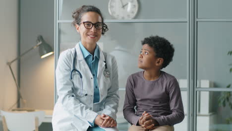 retrato de un feliz niño afroamericano y una doctora en la clínica