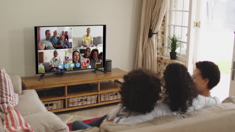 african american family having a video call on tv while sitting on the couch at home