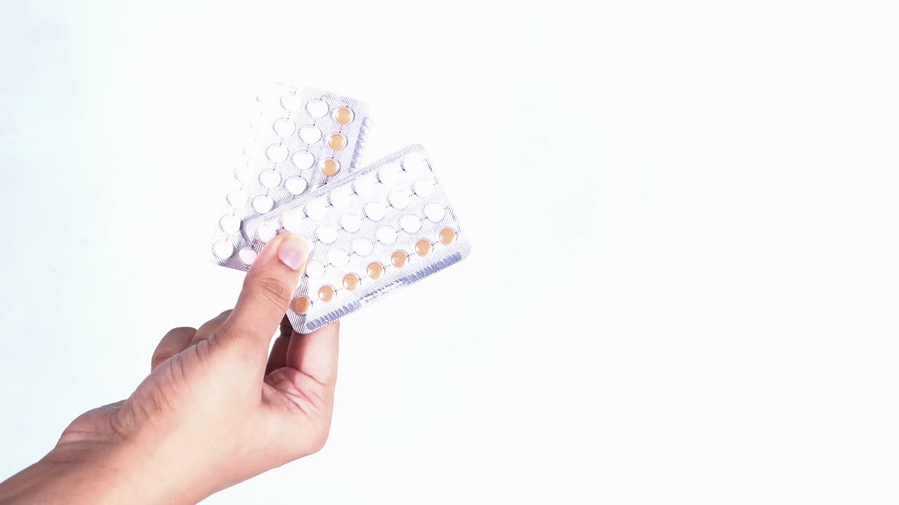 Mano sosteniendo pastillas anticonceptivas