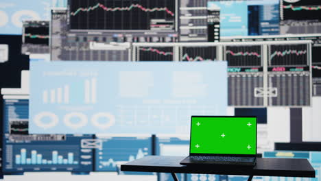 laptop with copy space display on empty desk next to infographics reports