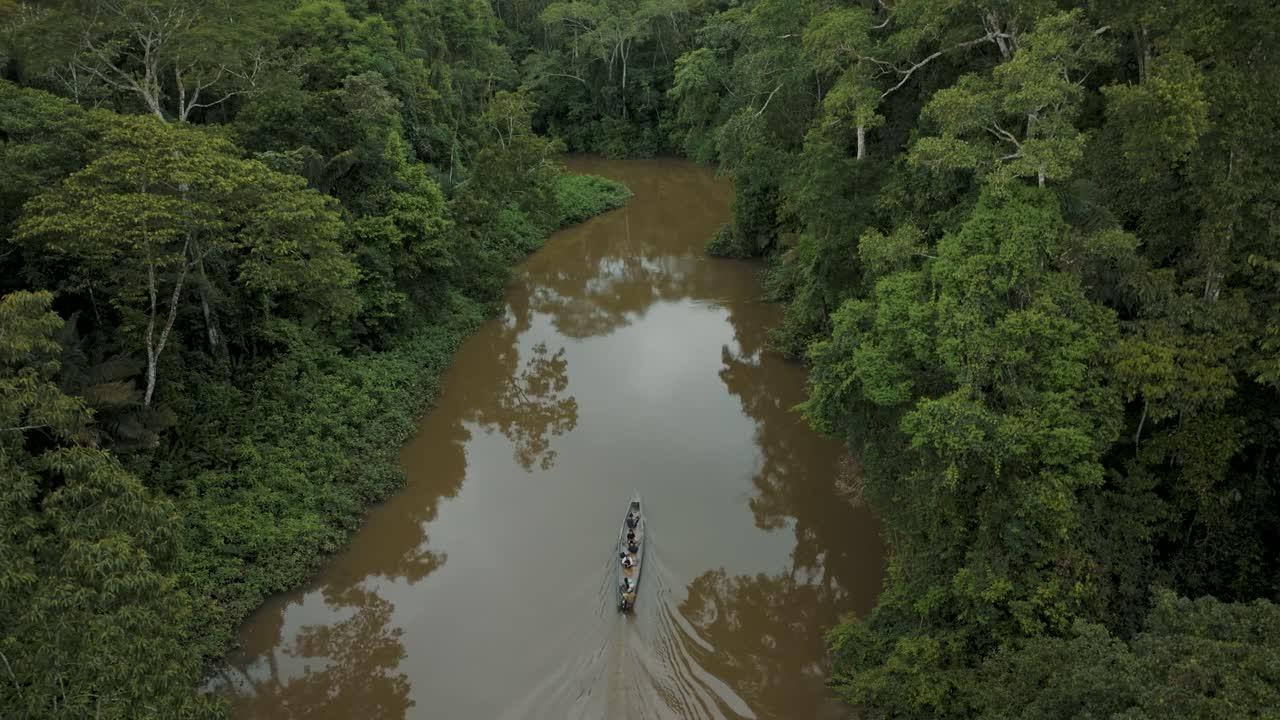 agua de río marrón con barco de madera navegando en la selva amazónica