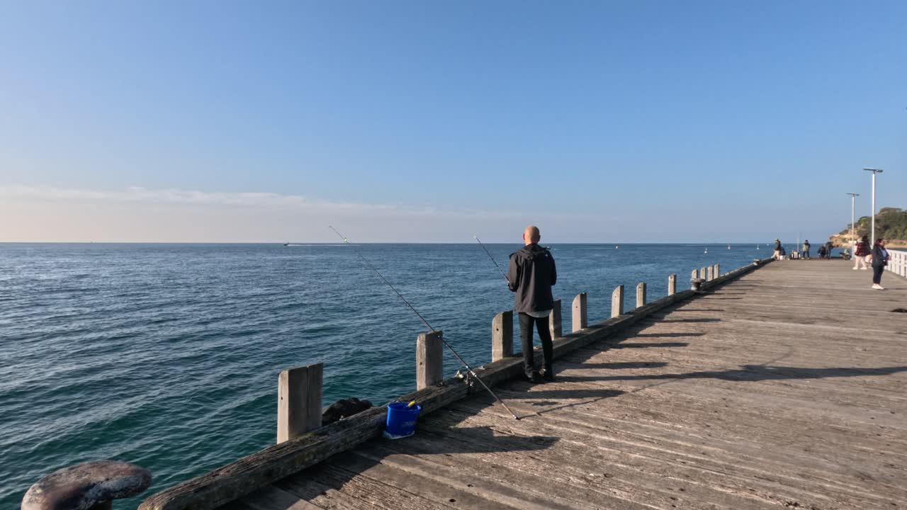 Man fishing on a sunny pier