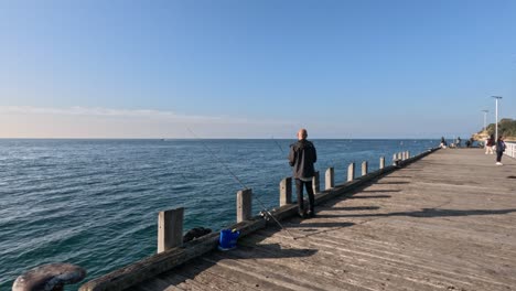 man fishing on a sunny pier