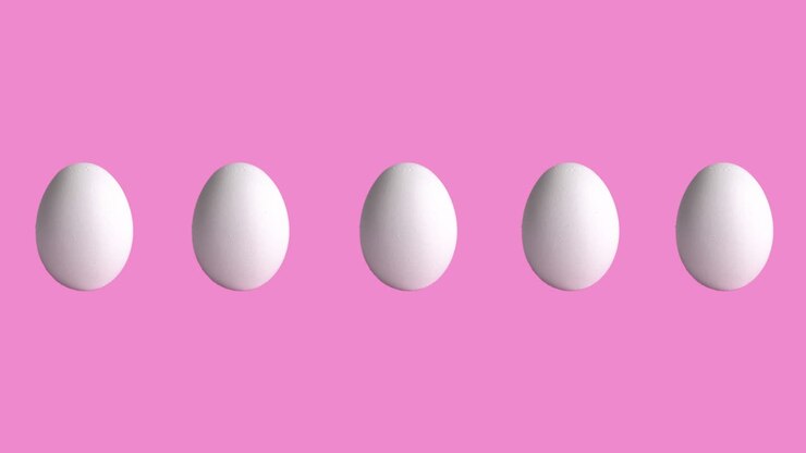 funny animation with chicken raw eggs on rose and pink background, close-up. side view of farm products, easter concept with copy space