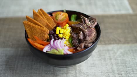 cuenco de comida con tortillas, maíz, carne, chiledulce, frijoles, tomates, almuerzo