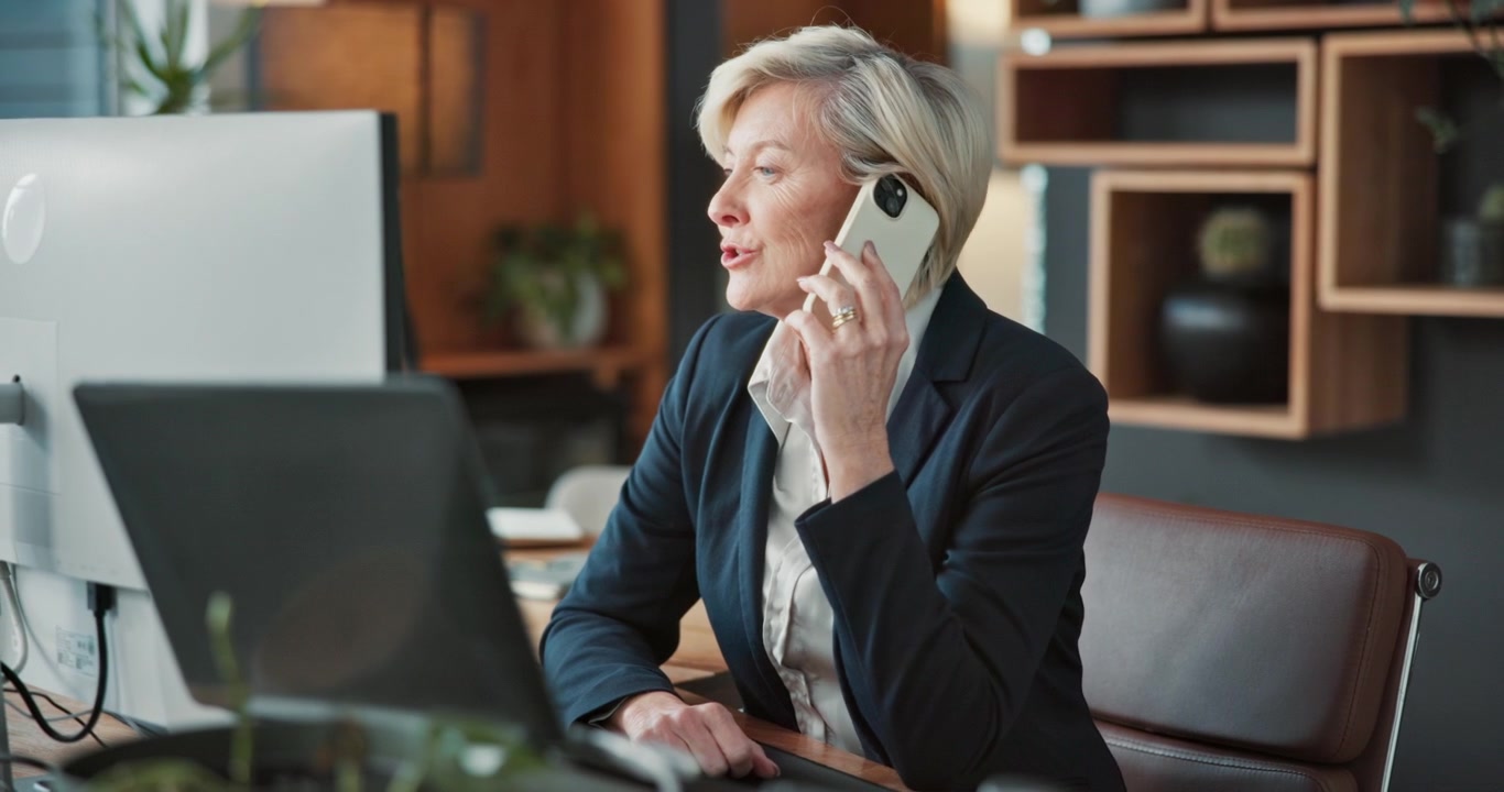 Mature Businesswoman Talking on Smartphone in Modern Office