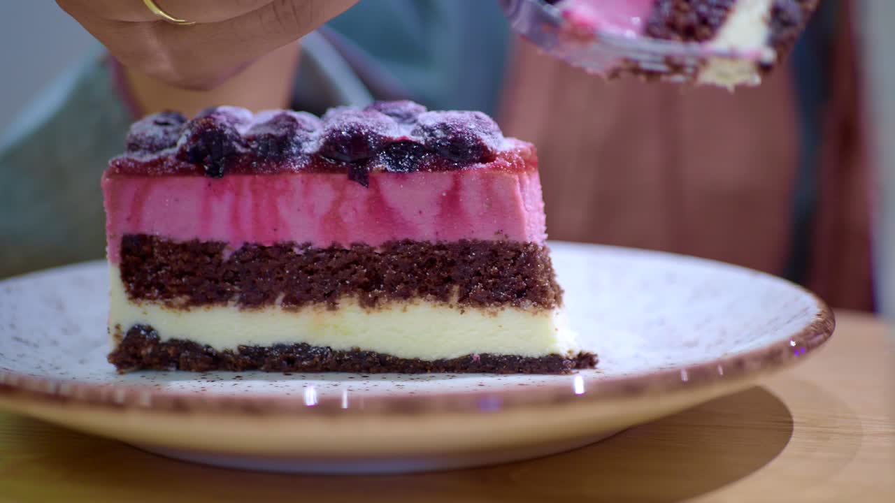 persona comiendo un pedazo de pastel de varias capas