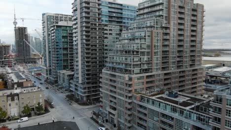 drone volando a lo largo de edificios de apartamentos en un día nublado en el centro de toronto