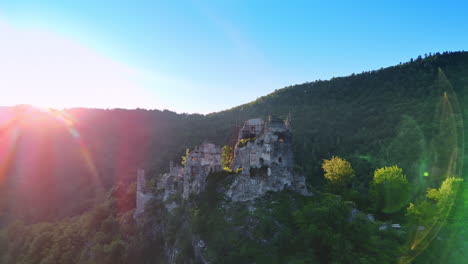 flight around the castle ruins supported by the scaffolding on the rock. tatra mountain range in slovakia at backdrop