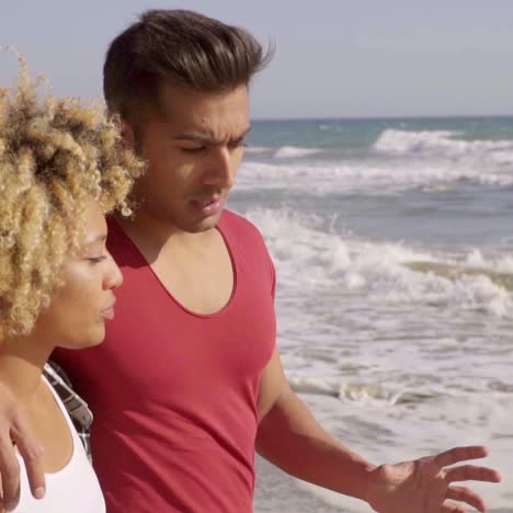 jeune couple métis debout sur la plage