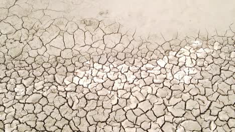 dry cracked drought fractured land aerial view descending to hot barren environment