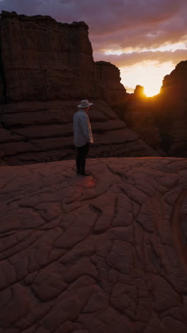 lone figure gazing at sunset over desert rock formations