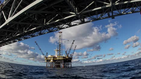 offshore oil rig under a bridge