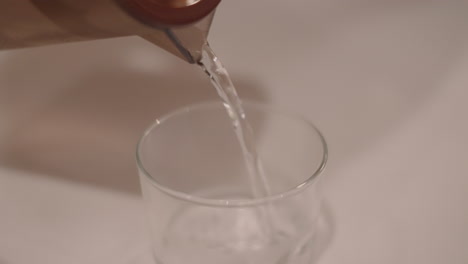 wasser wurde aus einem krug auf ein glas gegossen