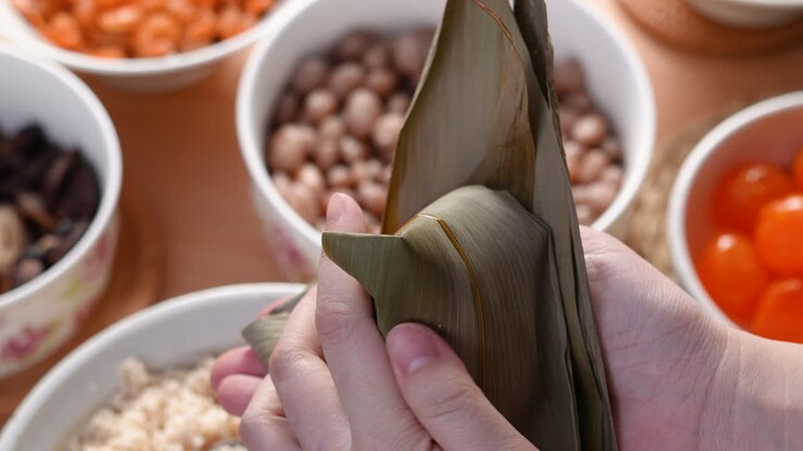 Making zongzi food - preparing and wrapping Chinese rice dumpling.