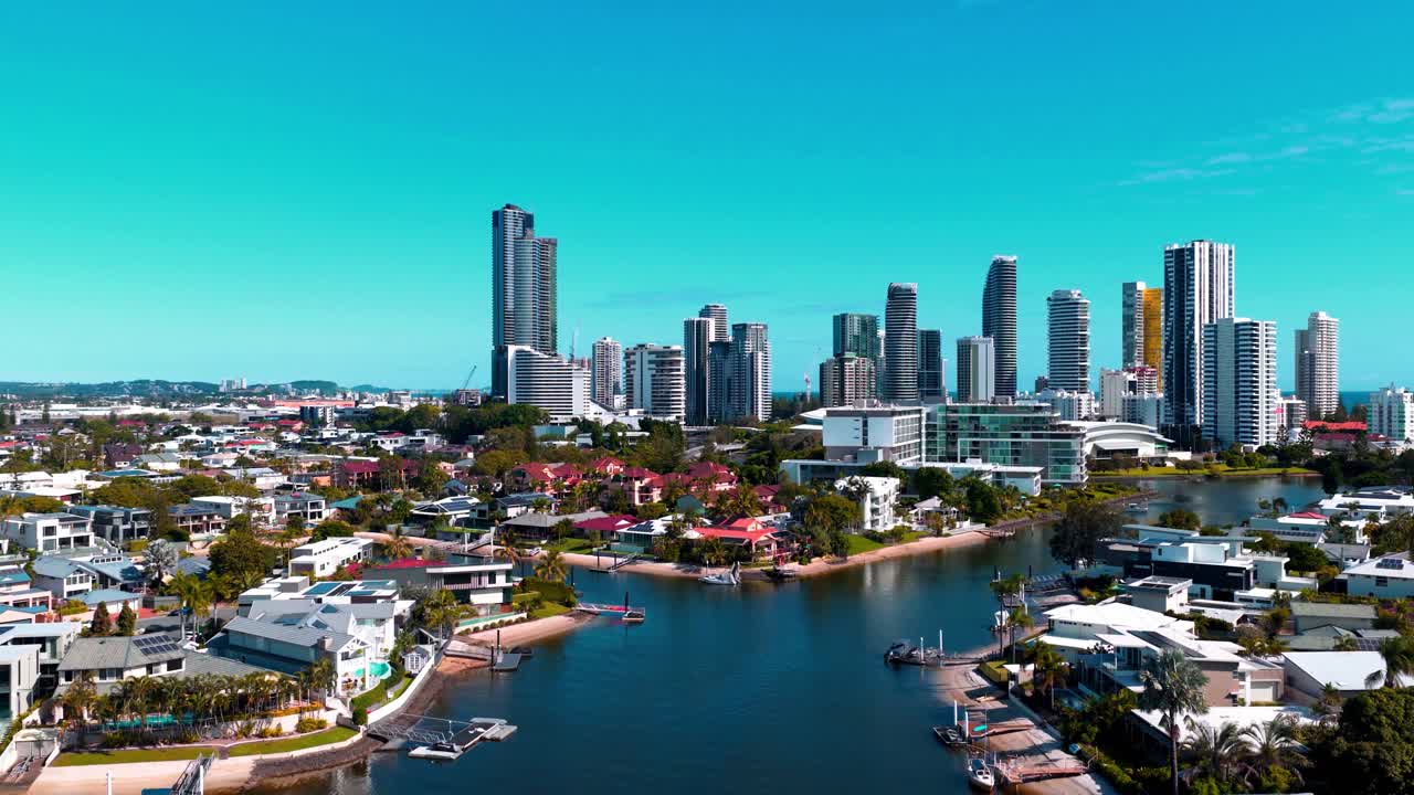 Droneoptagelse af Broadbeach Waters på Gold Coast, Queensland, med luksuriøse kanalhuse, rolige vandveje og en moderne skyline under en klar blå himmel.