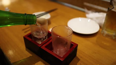 sequence of sake being poured into a glass cup